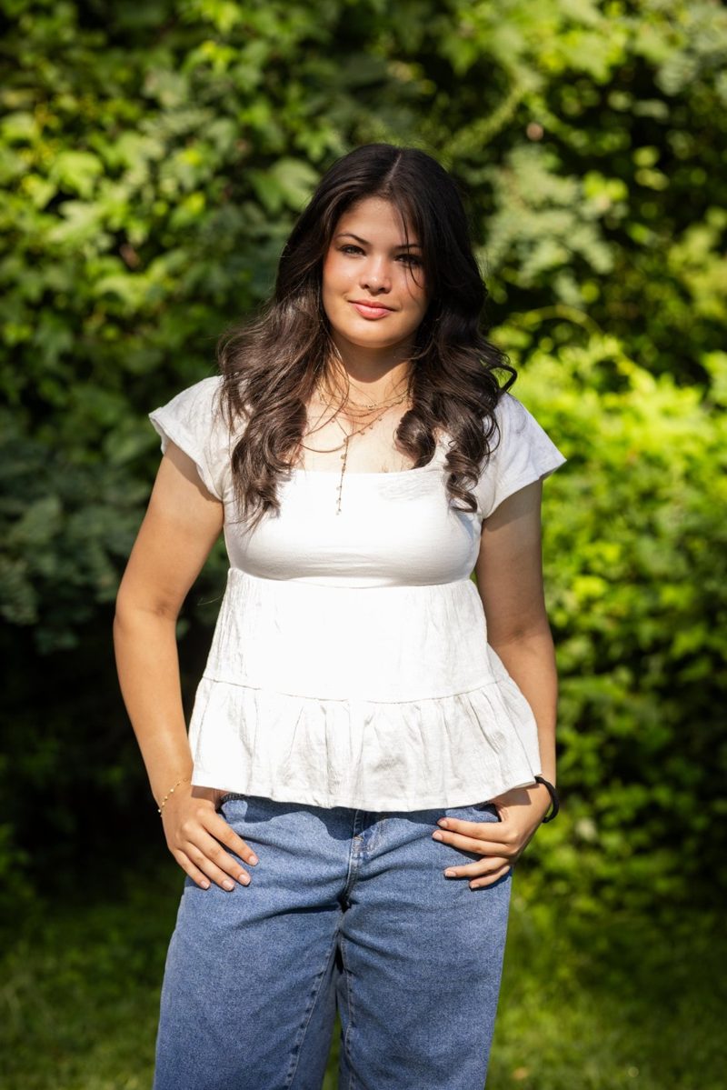 Portrait of Anya Gunnar standing outdoors in front of green leaves