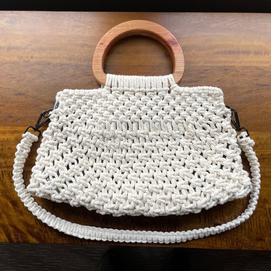 Knotted cotton cord bag with a braided shoulder strap.